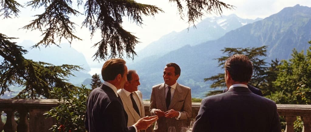 Investment committee partners on Alpine terrace overlooking lake